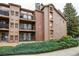 Multi-level condo building with brown wood siding, brick accents, and private balconies at 4899 S Dudley St # 15B, Littleton, CO 80123