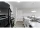 Modern kitchen has black appliances, white cabinets, sleek countertops, and updated lighting at 4899 S Dudley St # 15B, Littleton, CO 80123