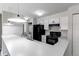 Bright kitchen features black appliances, white cabinets, breakfast bar and stacked washer/dryer at 4899 S Dudley St # 15B, Littleton, CO 80123