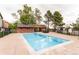 Sparkling community pool with lounge chairs, wooden structures, and mature trees at 4899 S Dudley St # 15B, Littleton, CO 80123