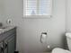 Half bathroom with a gray vanity, granite countertop, and window providing natural light at 4777 S Olathe St, Aurora, CO 80015