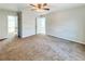 Spacious bedroom with neutral carpeting and a ceiling fan, featuring a walk-in closet and attached bathroom at 4777 S Olathe St, Aurora, CO 80015