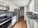 Modern kitchen featuring stainless steel appliances, granite countertops, and mosaic backsplash at 4777 S Olathe St, Aurora, CO 80015