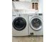 Washer and dryer in the laundry room with white shelving above appliances at 4777 S Olathe St, Aurora, CO 80015