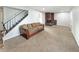 A cozy living room featuring a brick fireplace, a plush sofa, and a staircase with iron railings at 4777 S Olathe St, Aurora, CO 80015