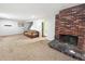 The carpeted living room has a brick fireplace and neutral walls, with a staircase visible in the background at 4777 S Olathe St, Aurora, CO 80015