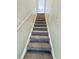 Carpeted stairs with a metal hand railing that leads to the upper level of the house at 4777 S Olathe St, Aurora, CO 80015