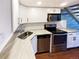 Bright kitchen featuring stainless steel appliances, stylish countertops, and white cabinets at 1885 S Quebec Way # H27, Denver, CO 80231