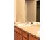 Clean bathroom featuring double sinks, wood vanity and a large mirror with a shower in the background at 3220 Boulder Cir # 103, Broomfield, CO 80023