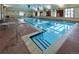 Bright indoor pool featuring blue and white pennant flags, multiple windows, and pristine blue water at 3220 Boulder Cir # 103, Broomfield, CO 80023