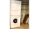 Convenient laundry closet with a stacked washer and dryer unit and built-in shelving at 3220 Boulder Cir # 103, Broomfield, CO 80023