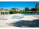 Community pool featuring plentiful lounge chairs, sunshades, and clear blue skies and landscaping at 3220 Boulder Cir # 103, Broomfield, CO 80023