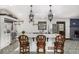 Bright kitchen features an island with bar seating, white cabinets, stainless steel appliances, and unique patterned tile floors at 19 Rock Ln, Castle Rock, CO 80104