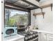 Bright kitchen features a stainless steel stove, range hood, patterned backsplash, and a view of the mountain from the window at 19 Rock Ln, Castle Rock, CO 80104