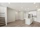 Open-concept living room featuring wood floors, recessed lighting, stairs, and kitchen island at 6541 N Malaya St, Aurora, CO 80019