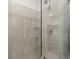 The elegant tiled shower features clear glass doors and modern fixtures at 6541 N Malaya St, Aurora, CO 80019