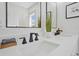 Bright bathroom featuring dual sinks, modern black fixtures, and a sleek, minimalist design at 5612 Ammons St, Arvada, CO 80002