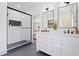 Modern bathroom with dual vanities, walk-in shower, and sleek black and white finishes at 5612 Ammons St, Arvada, CO 80002