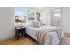 Bright bedroom features a light color scheme, hardwood floors and three large windows at 5612 Ammons St, Arvada, CO 80002