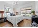 Bright bedroom features wood floors, white walls, and a modern chandelier at 5612 Ammons St, Arvada, CO 80002