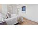 Sunlit bedroom with hardwood floors features a cozy bed with a view to the bathroom at 5612 Ammons St, Arvada, CO 80002