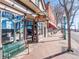 Coffee and bourbon lounge exterior view, with a sidewalk bench and tree-lined street on a sunny day at 5612 Ammons St, Arvada, CO 80002