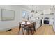 Bright kitchen with white cabinets, an island with pendant lights, and a wooden dining table near a large window at 5612 Ammons St, Arvada, CO 80002