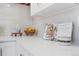 Close-up of a white kitchen counter with decorative items and a cookbook open to a recipe at 5612 Ammons St, Arvada, CO 80002