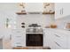 Kitchen featuring an oven, white countertops, modern hardware, and open shelving at 5612 Ammons St, Arvada, CO 80002