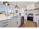 Bright kitchen with a white countertop island, stainless steel appliances, and a large window overlooking the yard at 5612 Ammons St, Arvada, CO 80002