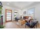 Cozy living room featuring a stylish leather sofa, wood floors, and abundant natural light at 5612 Ammons St, Arvada, CO 80002
