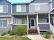 Inviting townhome featuring a charming front porch, landscaped yard, and two-tone gray and blue color scheme at 19246 E Idaho Pl # 102, Aurora, CO 80017