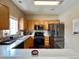 Well-lit kitchen features stainless steel appliances, wooden cabinetry, and warm lighting at 19246 E Idaho Pl # 102, Aurora, CO 80017