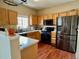 Well-lit kitchen features stainless steel appliances, wooden cabinetry, and warm lighting at 19246 E Idaho Pl # 102, Aurora, CO 80017