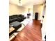 Cozy living room featuring a large sectional sofa and hardwood floors leading to dining area at 19246 E Idaho Pl # 102, Aurora, CO 80017