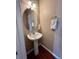 Small powder room with single sink vanity, oval mirror, and light fixture at 19246 E Idaho Pl # 102, Aurora, CO 80017