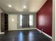 An open living room with dark floors and a striking red accent wall at 15962 E Exposition Dr, Aurora, CO 80017