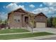 Craftsman home with stone facade, attached two-car garage and well-manicured front lawn at 23636 E Del Norte Pl, Aurora, CO 80016