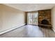 Bright living room featuring hardwood floors, a brick fireplace, and sliding glass doors to a private balcony at 1300 S Parker Rd # 9, Denver, CO 80231