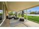 Covered back porch with seating and an outdoor rug overlooking the green lawn at 7751 S Race St, Centennial, CO 80122