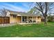 Spacious backyard featuring a covered back porch, well-maintained lawn, and mature trees at 7751 S Race St, Centennial, CO 80122