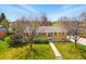 Charming single-story home with a well-maintained front yard, walkway, and mature trees under a bright blue sky at 7751 S Race St, Centennial, CO 80122