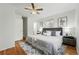 Cozy main bedroom featuring hardwood floors, ceiling fan, closet, and ensuite bathroom at 7751 S Race St, Centennial, CO 80122