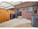 View of the back patio that has a brick wall, a sliding glass door, concrete, and a wooden fence at 9019 E Oxford Dr, Denver, CO 80237