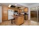 Well-lit kitchen with wood cabinetry, a functional island, and sliding glass doors at 9019 E Oxford Dr, Denver, CO 80237