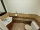 Cozy half bathroom featuring a toilet and vanity with decorative tile at 9019 E Oxford Dr, Denver, CO 80237