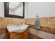 Compact half-bathroom with a sink vanity, large mirror, and decorative tile backsplash at 9019 E Oxford Dr, Denver, CO 80237