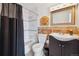 Bathroom with tiled walls, a decorative mirror, and a shower-tub combo at 9019 E Oxford Dr, Denver, CO 80237