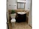 Bathroom featuring tiled shower-tub, decorative mirror, and sink with dark wood cabinetry at 9019 E Oxford Dr, Denver, CO 80237