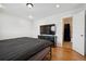 Bedroom featuring hardwood floors, a flat screen TV atop a dresser, and a nearby bathroom at 9019 E Oxford Dr, Denver, CO 80237
